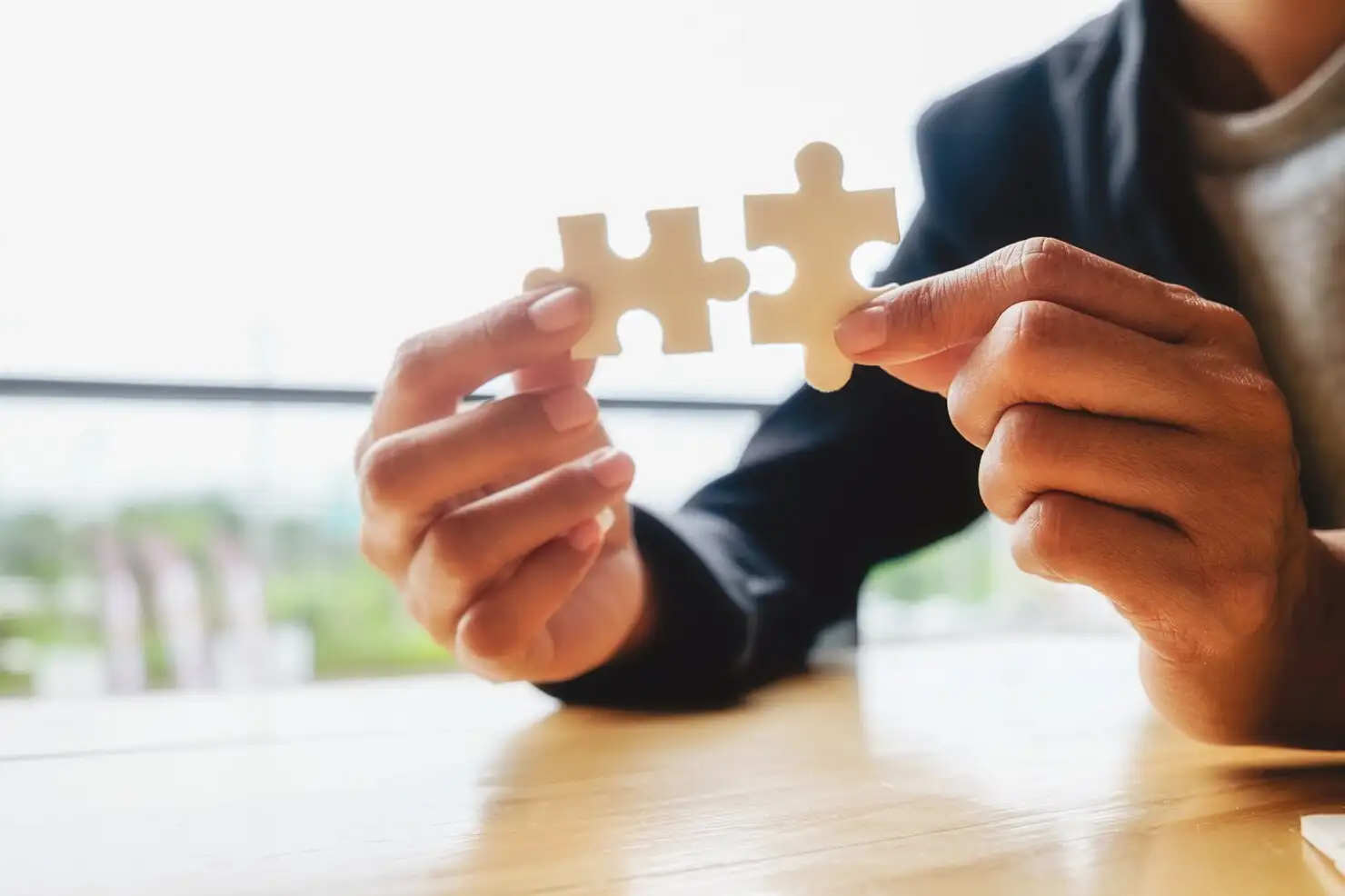 Duas peças de quebra-cabeça sendo encaixadas, representando a solução construída sob medida