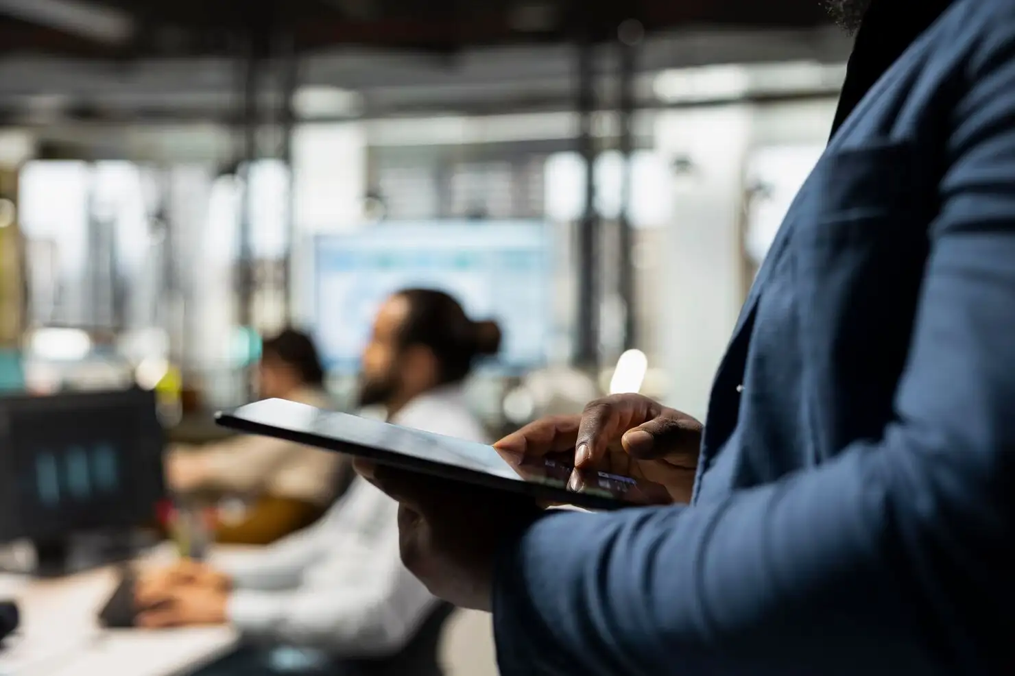 Profissional consultando um tablet em ambiente corporativo